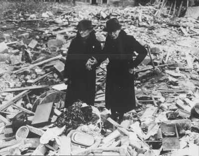 Newbury, England, 1943. Two women stand in the ruins of the almshouse that was their home.